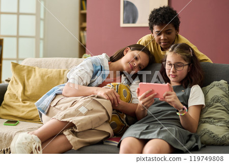 Children Relaxing on Couch and Watching Smartphone Together Children Relaxing on Couch and Watching Smartphone Together 119749808