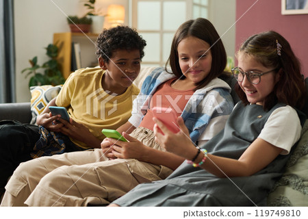 Children Playing on Smartphones in Living Room Setting 119749810