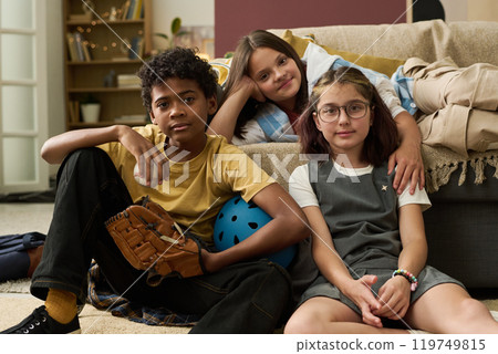 Children Relaxing with Sports Equipment in Living Room Children Relaxing with Sports Equipment in Living Room 119749815