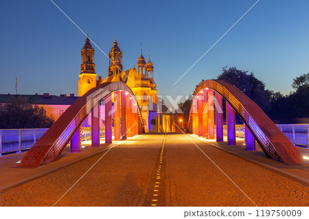 A view of the Cathedral Basilica of St. Peter and St. Paul seen through the vibrant red structure of the Jordan Bridge at sunrise in Poznan, Poland A view of the Cathedral Basilica of St. Peter and St. Paul seen through the vibrant red structure of the Jordan Bridge at sunrise in Poznan, Poland 119750009