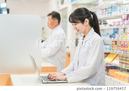 Pharmacists and dispensing staff working together at a pharmacy (laptop and tablet PC) 119750457