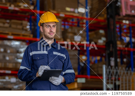 Man paper warehouse worker holding tablet checking inspecting quality cardboard corrugated carton in storage. Large industry in paper product line manufacturing. Man paper warehouse worker holding tablet checking inspecting quality cardboard corrugated carton in storage. Large industry in paper product line manufacturing. 119750589