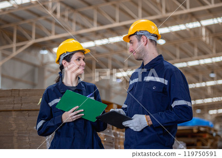 Paper warehouse worker holding clipboard and tablet checking inspecting quality cardboard corrugated carton in storage. Large industry in paper product line manufacturing. 119750591