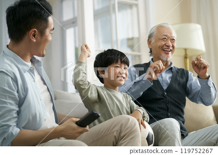 asian son father grandfather watching soccer game on TV together at home 119752267
