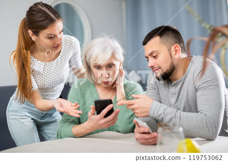 Adult children help an elderly mother learn how to use smartphone 119753062