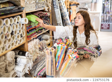 Woman choosing rug at household goods shop 119753176