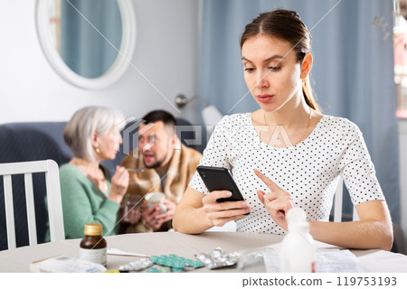Young woman choosing medicines for sick husband 119753193