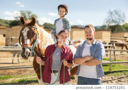 Happy family spending time together at small horse farm 119753201