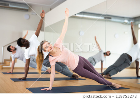 Woman and men exercising side plank on fitness training 119753278