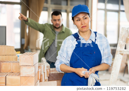 Depressed woman builder offended by construction manager 119753282