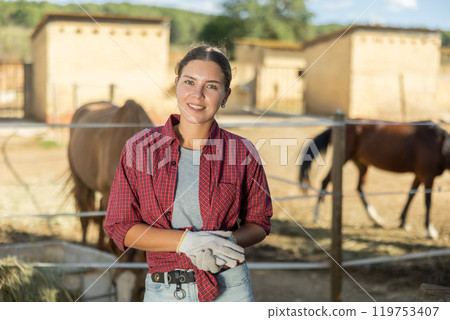 Young woman posing near horse paddock Young woman posing near horse paddock 119753407