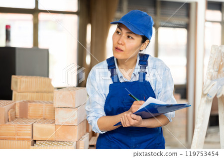Portrait of an asian builder woman who checks completed work on 119753454