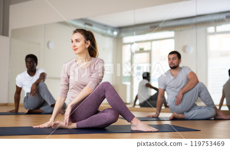 Woman and men practising lord of the fishes pose 119753469