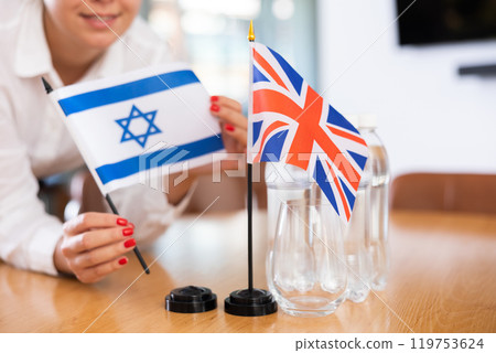 Office coordinator setting flags of Israel and United Kingdom on table 119753624