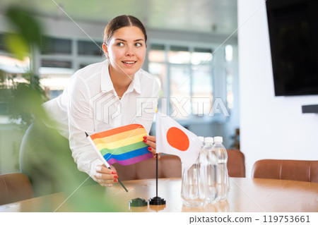 Female office coordinator setting flags of Japan and LGBT community on negotiating table Female office coordinator setting flags of Japan and LGBT community on negotiating table 119753661