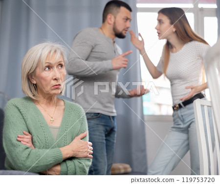 Mature woman waiting for couple stop quarreling Mature woman waiting for couple stop quarreling 119753720