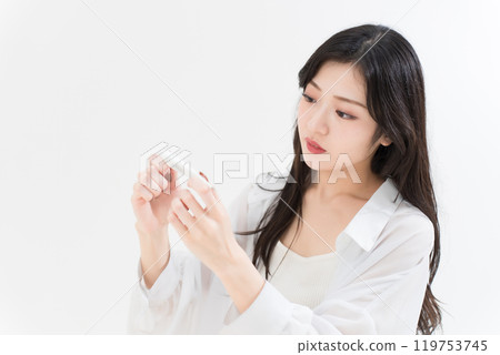 Young woman looking at a thermometer 119753745