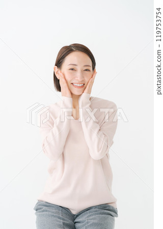 A woman in her 30s smiling with her hand on her cheek A woman in her 30s smiling with her hand on her cheek 119753754