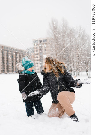 Mother and child are playing in the snow Mother and child are playing in the snow 119755866