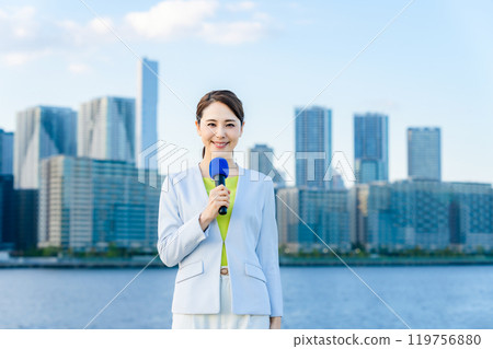 Female announcer standing in front of the city 119756880