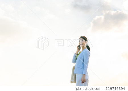 一個女人在天空中用智能手機說話 一個女人在天空中用智能手機說話 119756894