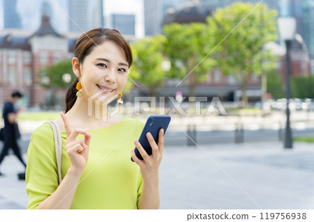 A woman with a smartphone against the backdrop of the city 119756938