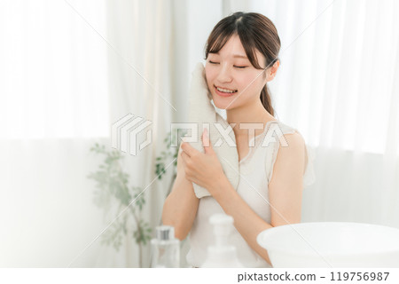 年輕的亞洲女人洗臉並用毛巾擦乾（洗臉） 119756987