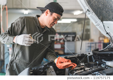 Middle-aged Asian man, mechanic, auto mechanic working at a repair shop Middle-aged Asian man, mechanic, auto mechanic working at a repair shop 119757175