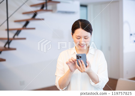 日本女人在客廳看智慧型手機 119757825