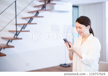 日本女人在客廳看智慧型手機 119757826