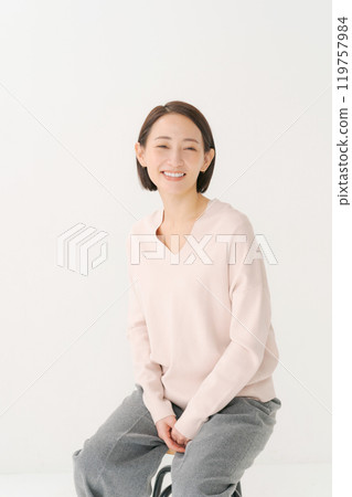Portrait of a middle-aged woman sitting on a chair 119757984