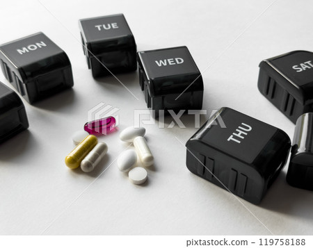 Weekly pill organizer with multicolored capsules and tablets for daily medication management 119758188