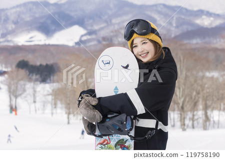 年輕女子捧著一個滑雪板 年輕女子捧著一個滑雪板 119758190