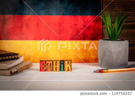 ETHICS Concept. Text in German. Alphabet blocks on a white painted wooden background 119758287