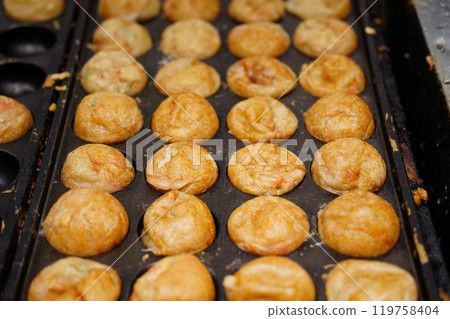 Takoyaki is a Japanese dish made by putting octopus in a flour batter and baking it Takoyaki is a Japanese dish made by putting octopus in a flour batter and baking it 119758404