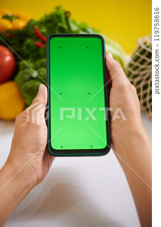 Holding Smartphone with Green Screen for Mockup Display Holding Smartphone with Green Screen for Mockup Display 119758616