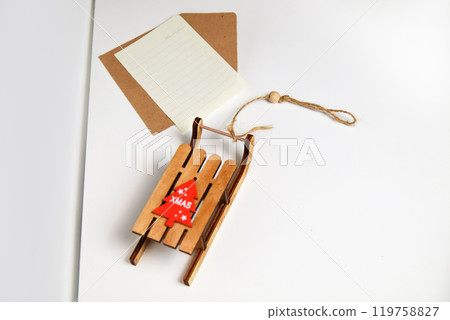 A festive image of a Christmas card featuring a traditional sleigh and a letter addressed to Santa, all set against a clean white background. The card captures the essence of holiday cheer 119758827