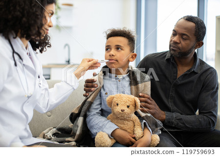 Female doctor checking temperature of young boy with father at home Female doctor checking temperature of young boy with father at home 119759693