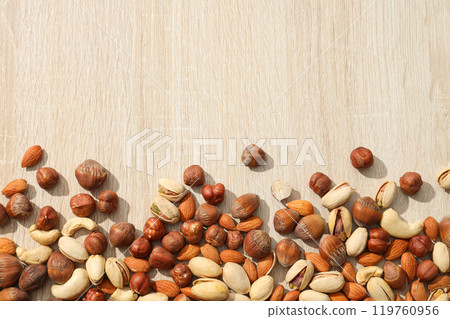 Assortment of different nuts on a wooden table Assortment of different nuts on a wooden table 119760956