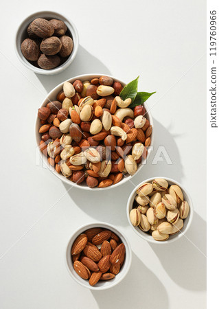 Various nuts in white bowls on a white background Various nuts in white bowls on a white background 119760966