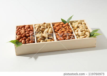 Wooden box with different nuts on a light background 119760973