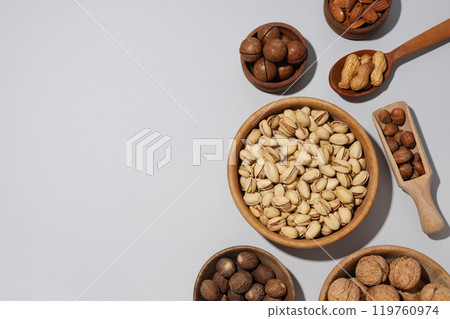 Various nuts in wooden bowls on a gray background 119760974