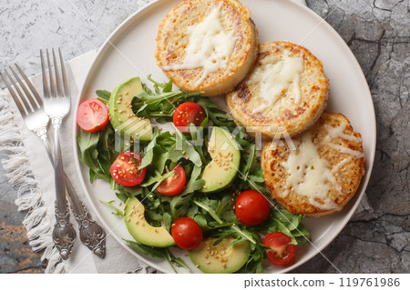 Fried crumpets in beaten egg with fresh vegetable salad for breakfast close-up in plate. Horizontal top view 119761986