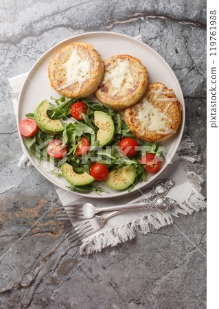 Breakfast Eggy Crumpets with vegetables salad closeup on the plate. Vertical top view 119761988