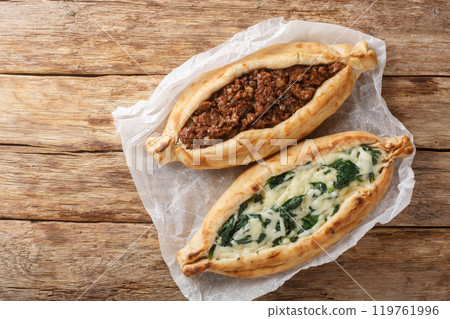 Turkish flat bread that comes stuffed with a variety of toppings, including cheese, spiced meat and spinach close-up. Horizontal top view Turkish flat bread that comes stuffed with a variety of toppings, including cheese, spiced meat and spinach close-up. Horizontal top view 119761996