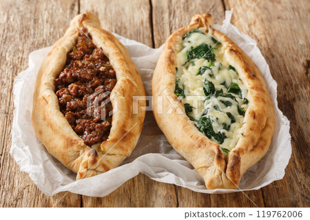 Pide Turkish Flat Bread Pizza with ground beef, Cheese, Spinach and Herbs close-up on wooden board. Horizontal 119762006