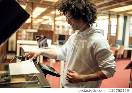 Young man making copies on xerox in the library Young man making copies on xerox in the library 119762139