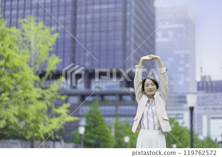 在辦公區伸展身體的女商人 119762572