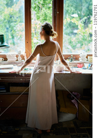 Beautiful young woman posing in craft workshop Beautiful young woman posing in craft workshop 119762701