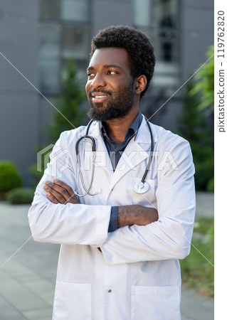 Man doctor standing at hospital wearing white medical gown and stethoscope Man doctor standing at hospital wearing white medical gown and stethoscope 119762820